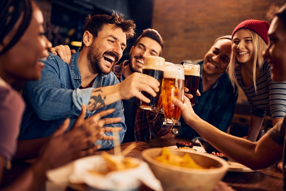 friends cheering glasses together in a bar setting